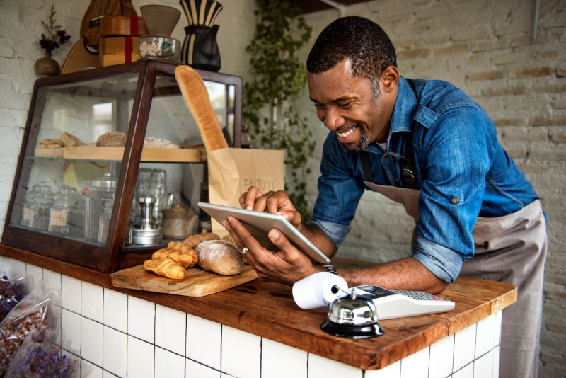 A bakery owner reviews his business financials in online banking.