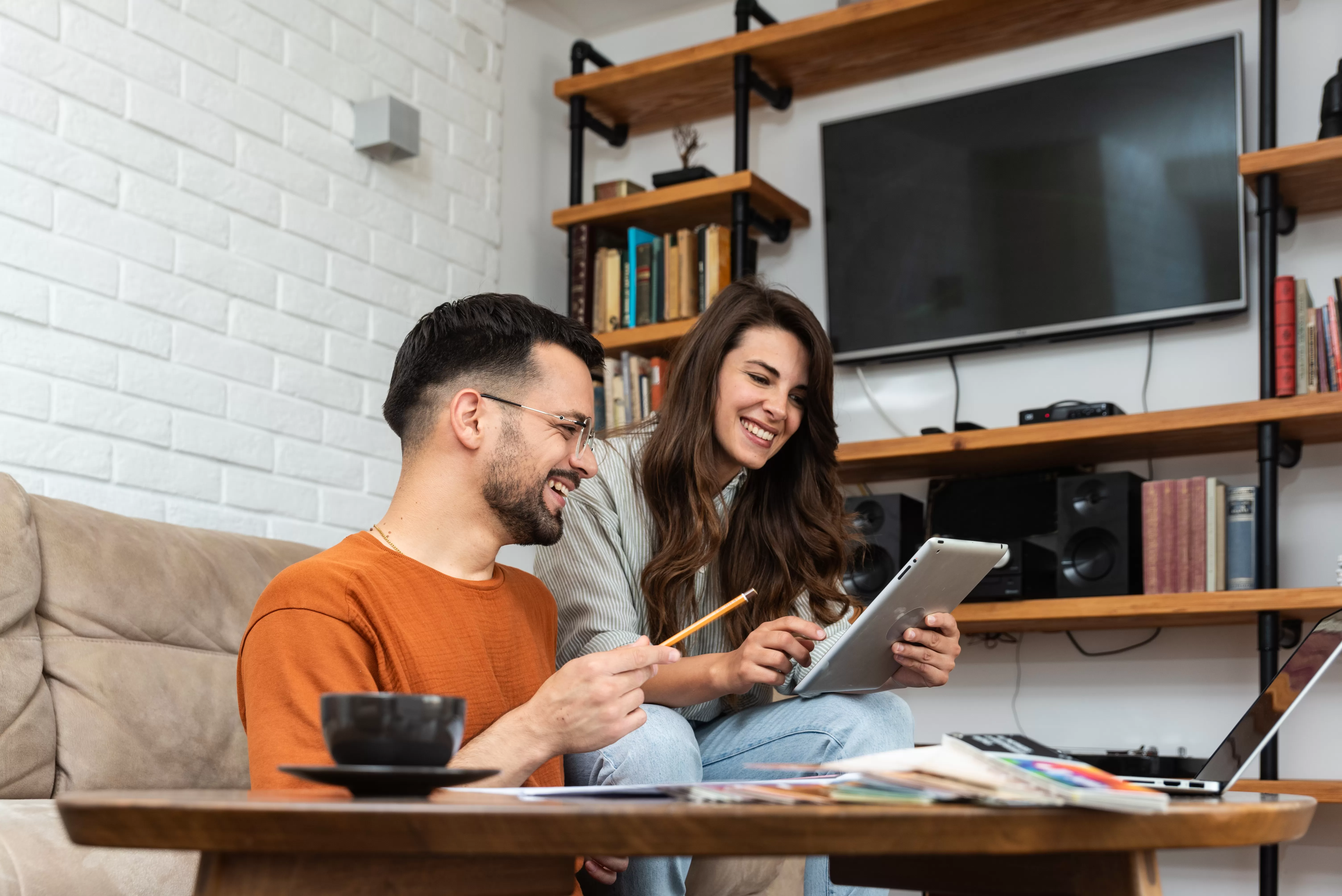 A young couple opening a credit union Roth IRA at home on their laptop.